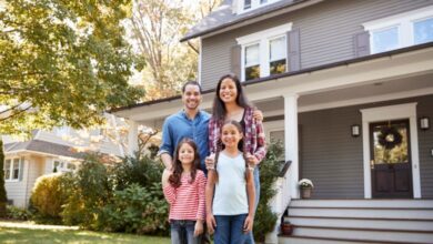 Portrait of a family standing in front of their home.