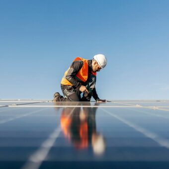 Man in vest and hard hat working on solar panels