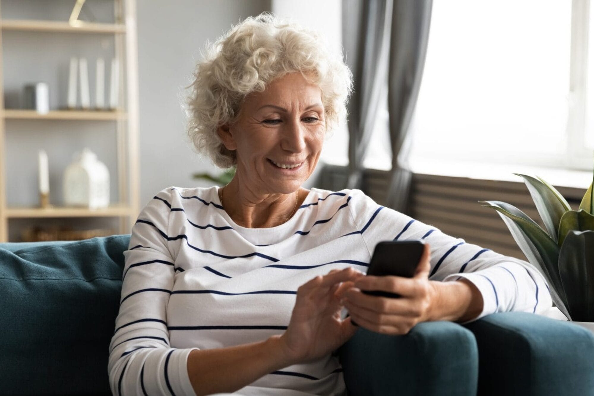 Woman sitting on couch while looking at smart phone